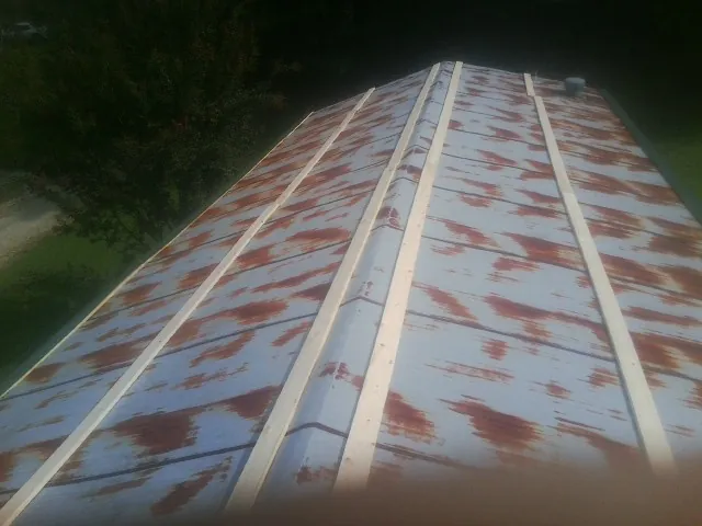 Rusted metal roof panels with new wood purlins before replacement — Storm Damage Roof Repair in Stonewall by Roofing Brothers
