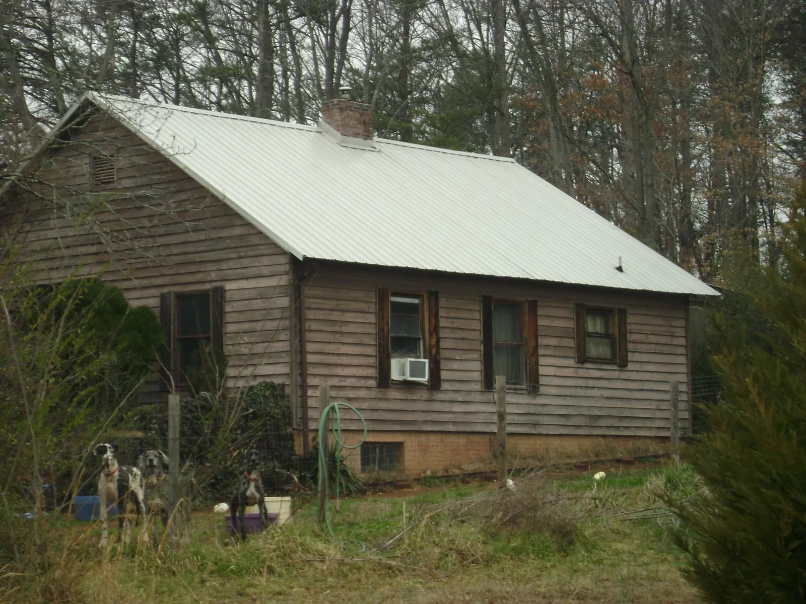 White metal roof on an old wood sided farmhouse, from a Metal Roof Installation job in Stonewall